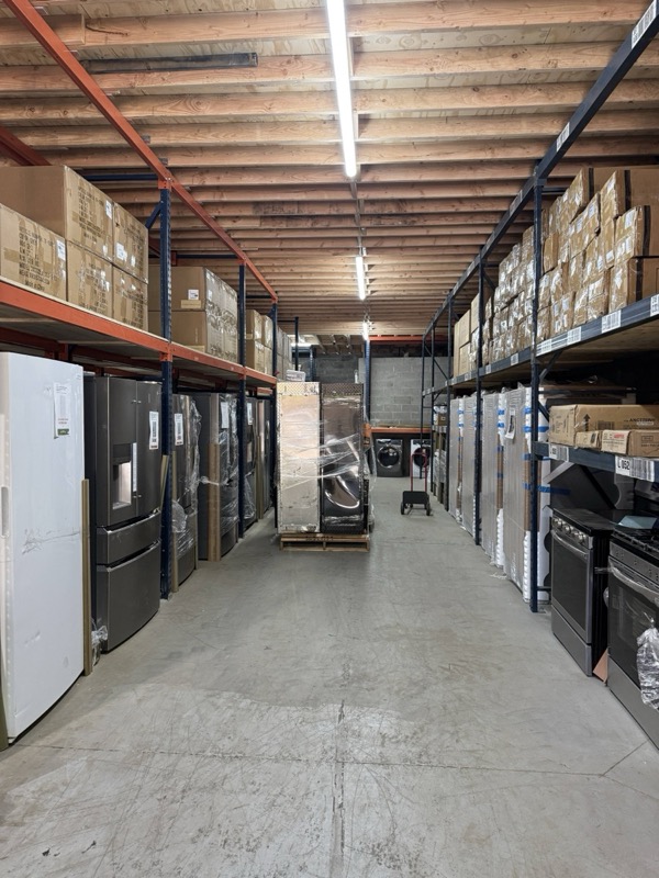 Inside the Bronx store: open aisle stocked with refrigerators, washers, dryers and stainless ranges