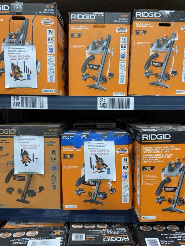 Ridgid wet/dry shop vacuums in original retail boxes stacked on warehouse shelving