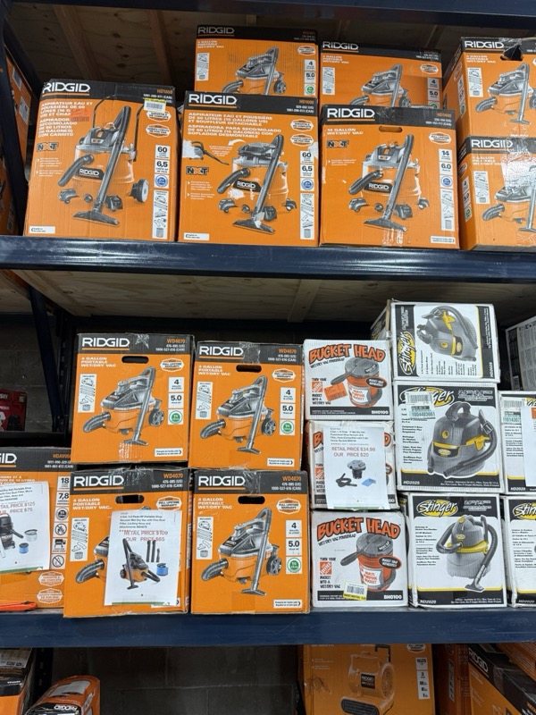 Ridgid wet/dry shop vacuums and Bucket Head accessories on warehouse shelving